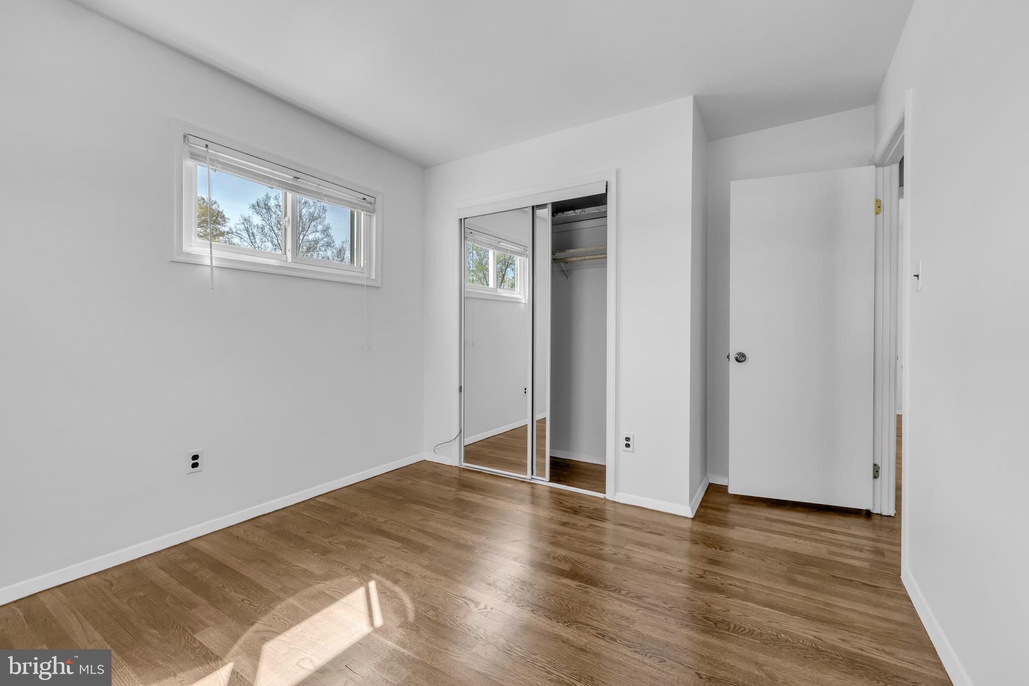 9807 Locust Avenue Lanham, MD 20706 - Photo 29 of 59 an empty room with wooden floor and windows