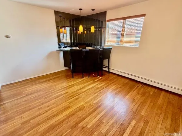 a view of a workspace with wooden floor and a window