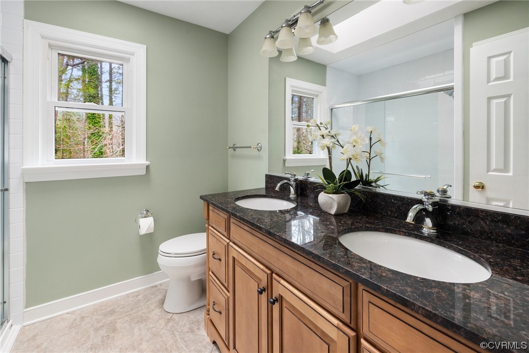 5716 Sandstone Ridge Road Midlothian, VA 23112 - Photo 23 of 36 a bathroom with a granite countertop double vanity sink a mirror and a toilet