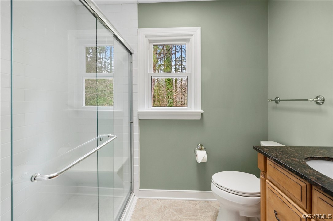 5716 Sandstone Ridge Road Midlothian, VA 23112 - Photo 24 of 36 a bathroom with a granite countertop toilet a sink and a window