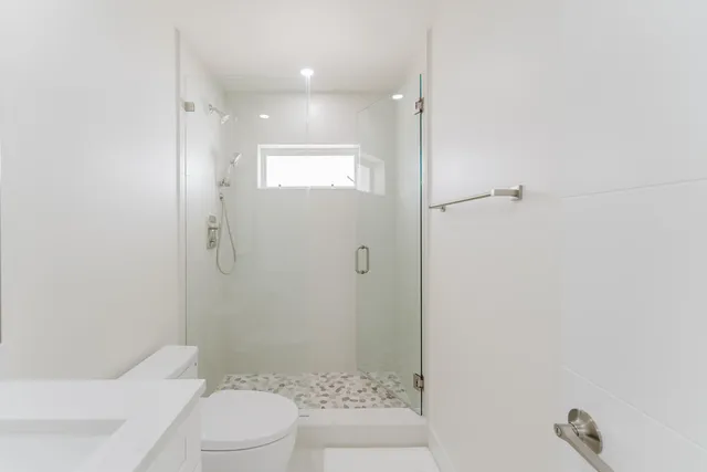 a bathroom with a shower a toilet and a shower