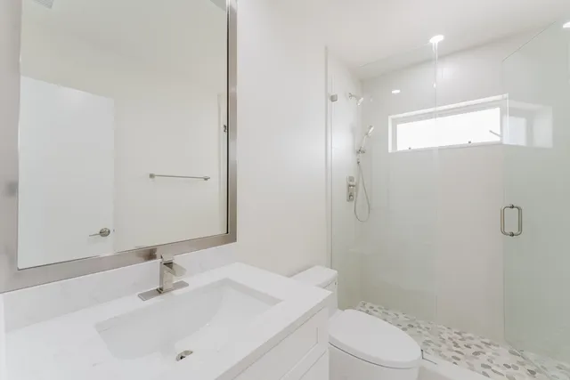 a bathroom with a sink a toilet and shower