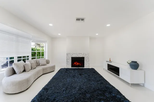 a living room with furniture a fireplace and a window
