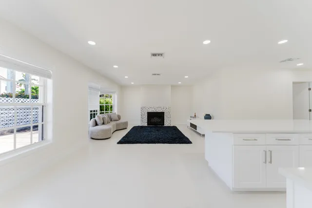 a large white room with a couch and a potted plant