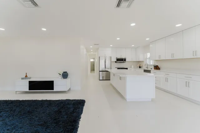 a kitchen with white cabinets and stainless steel appliances