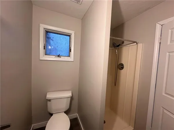 a bathroom with a toilet and a shower