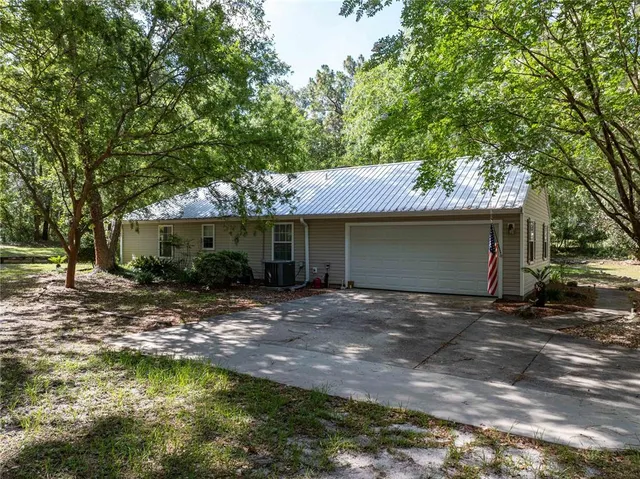 a view of a house with a yard garage and sitting area