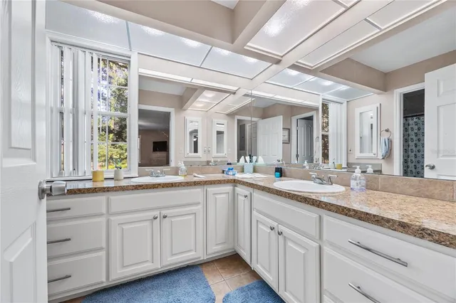 a bathroom with a granite countertop sink a mirror and shower
