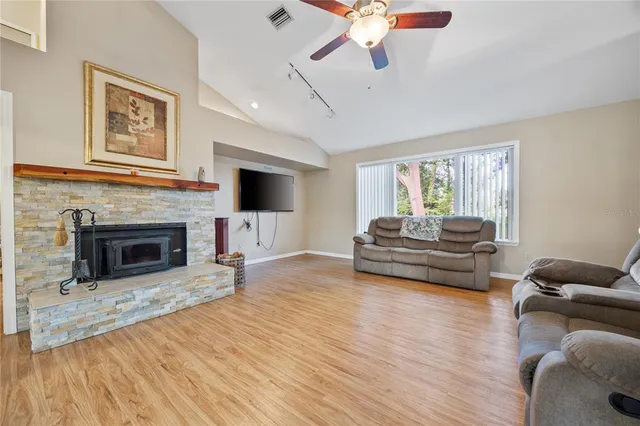 a kitchen with stainless steel appliances a dining table chairs and wooden floor