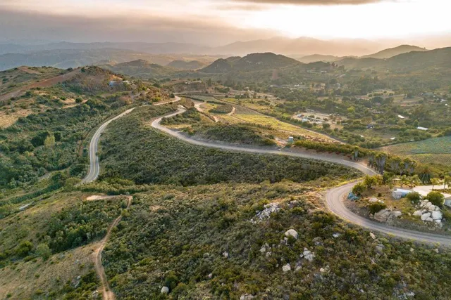 an aerial view of mountains residential house and green space