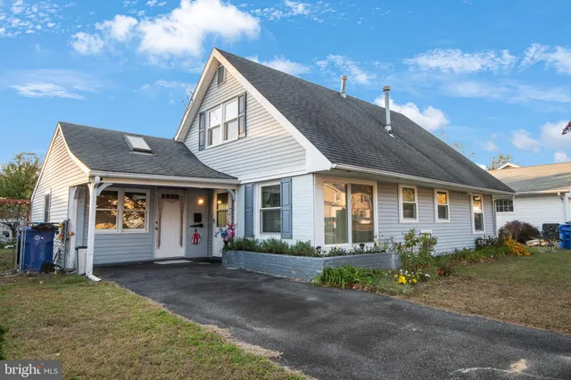 a front view of a house with a yard and potted plants
