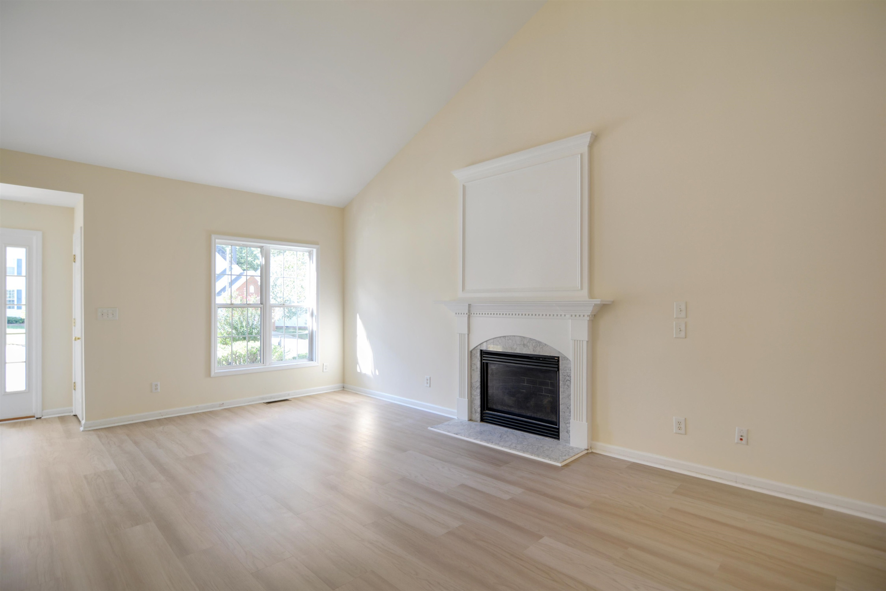 2708 Upper Dry Falls Court Raleigh, NC 27603 - Photo 4 of 16 an empty room with wooden floor fireplace and windows