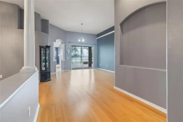 a view of a hallway with wooden floor and a chandelier
