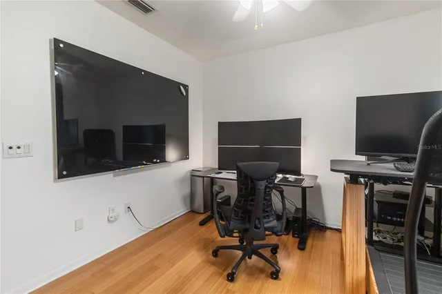 an empty room with wooden floor and windows
