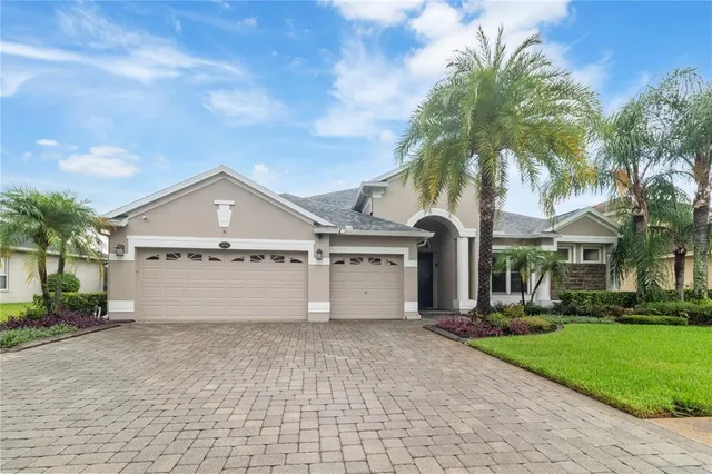a view of a house with a yard and palm trees