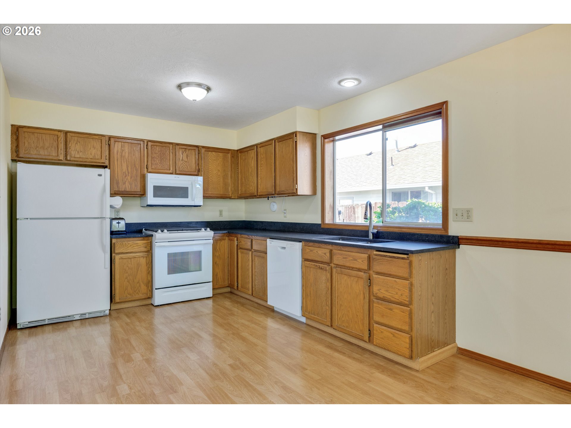 1360 North Locust Street Canby, OR 97013 - Photo 11 of 36 a kitchen with stainless steel appliances granite countertop a refrigerator sink and cabinets