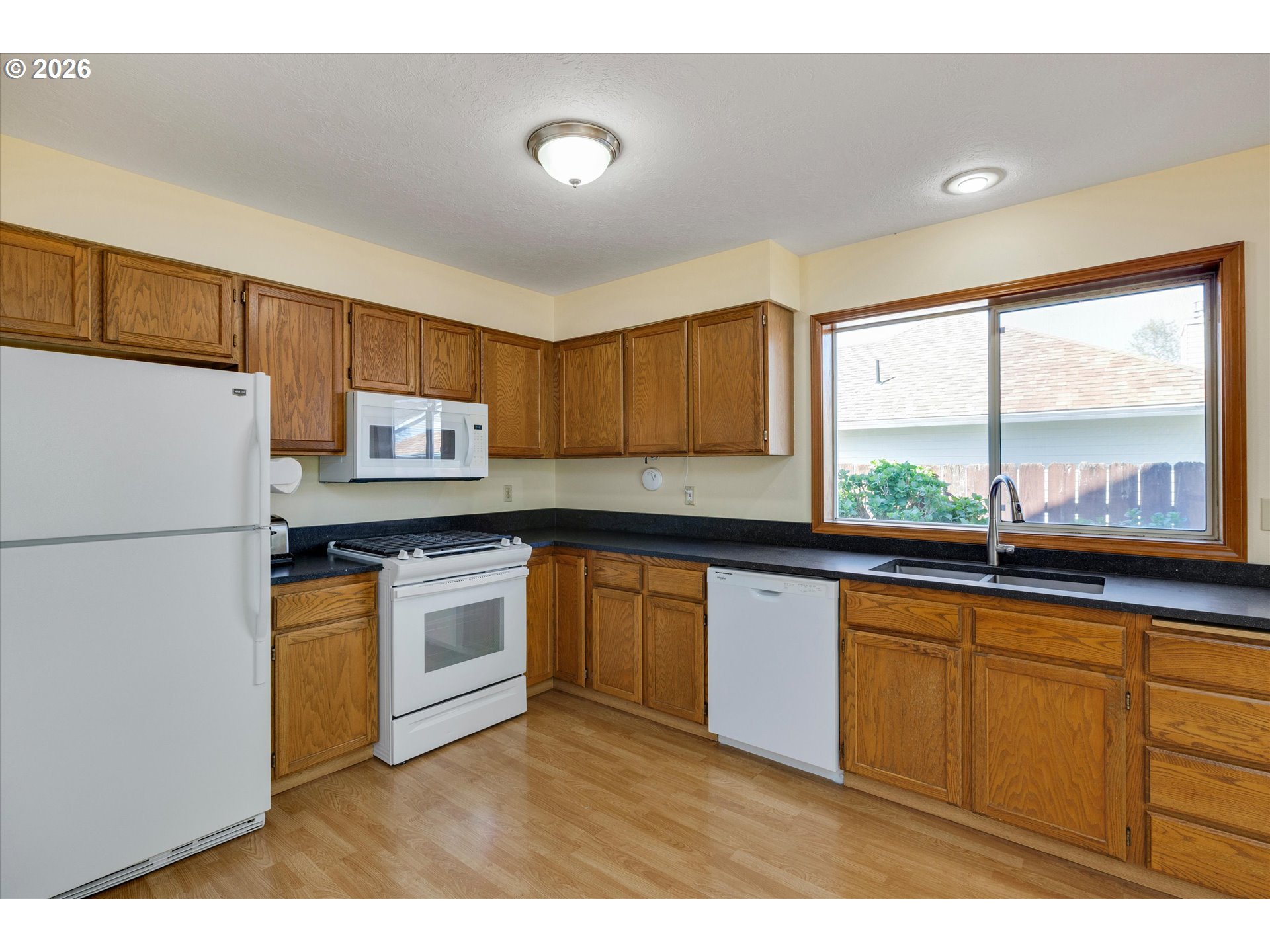 1360 North Locust Street Canby, OR 97013 - Photo 13 of 36 a kitchen with stainless steel appliances a refrigerator a sink a stove and white cabinets