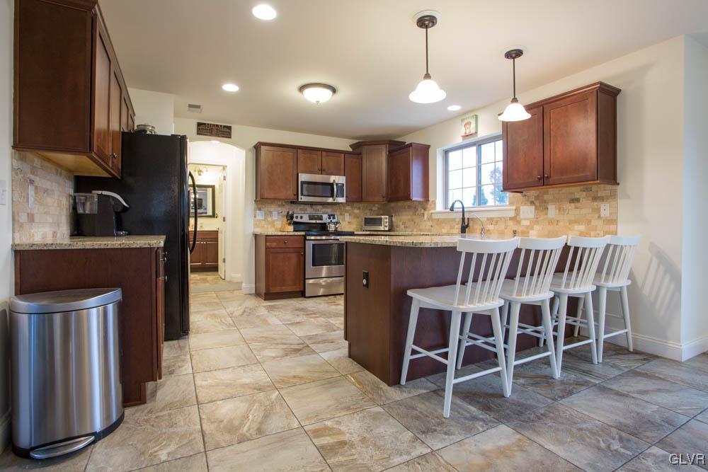 220 East Dell Road Bath, PA 18014 - Photo 8 of 26 a kitchen with stainless steel appliances granite countertop a stove top oven a sink a dining table and chairs