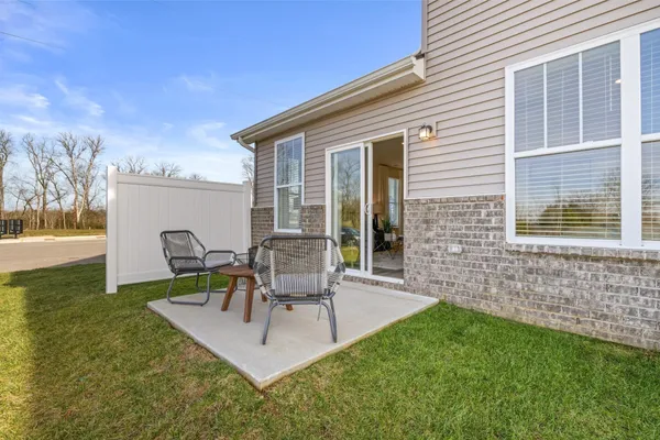 a view of backyard of house with a patio