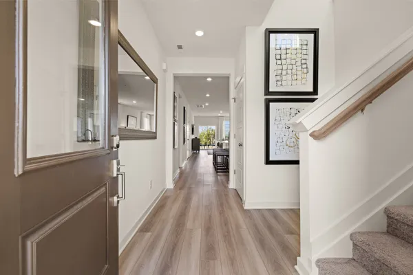a view of a hallway with wooden floor and staircase