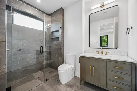 a bathroom with a double vanity sink toilet and shower