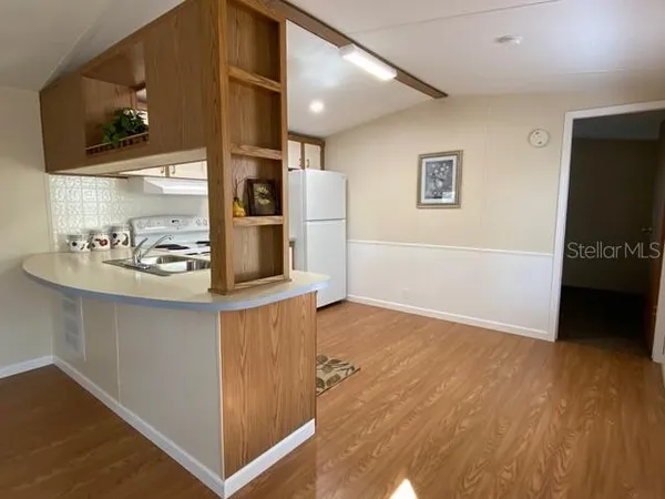 a kitchen with stainless steel appliances granite countertop a refrigerator and a stove top oven
