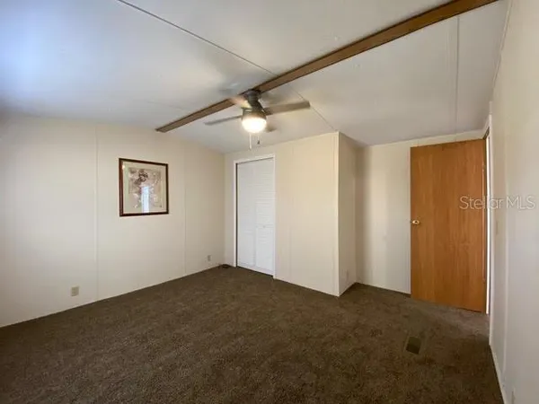 a view of an empty room with a ceiling fan