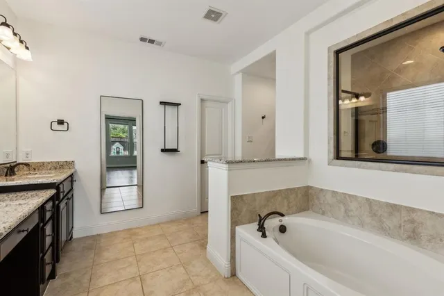 a bathroom with a tub sink and mirror