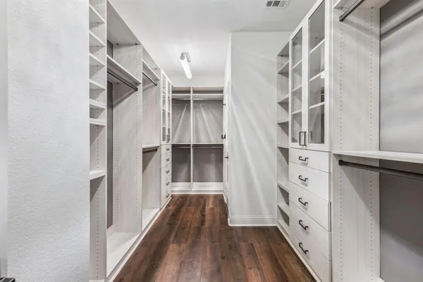 a view of walk in closet with empty racks