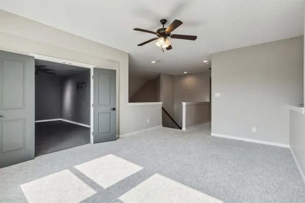 a view of a livingroom with a ceiling fan and wooden floor