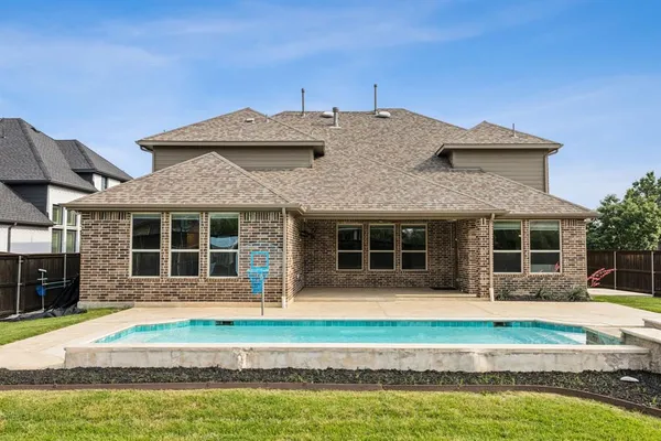 a front view of a house with a yard and swimming pool