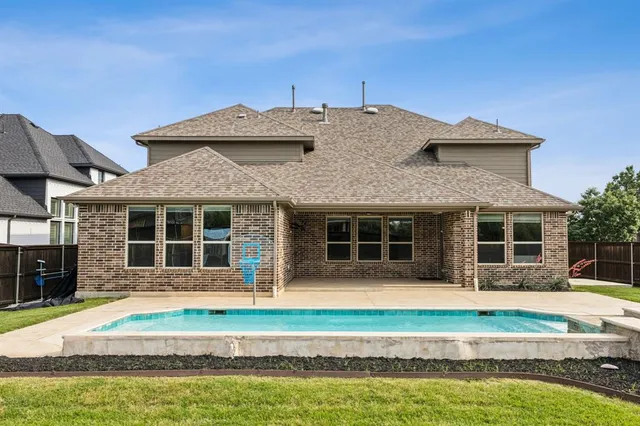 a front view of a house with a yard and swimming pool