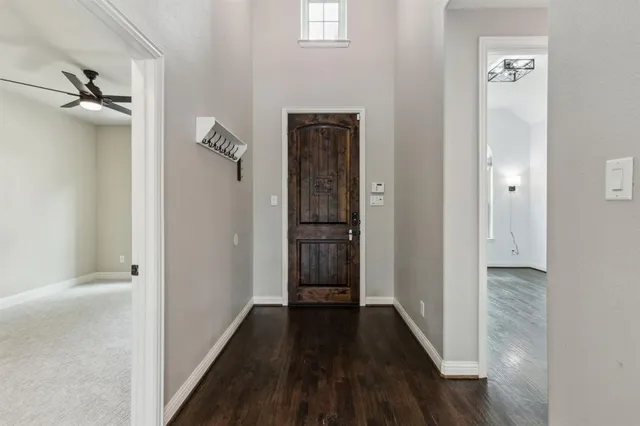 a view of a hallway with wooden floor and a bathroom