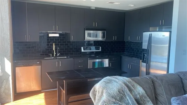 a kitchen with a sink a refrigerator and cabinets