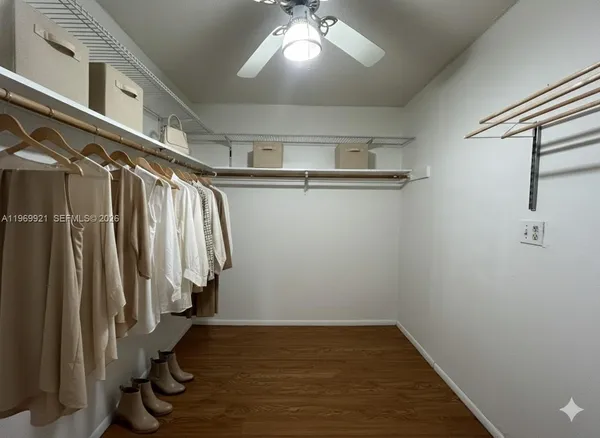 a view of walk in closet with clothes and shoes