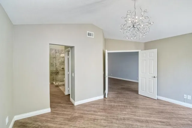 wooden floor in an empty room with a chandelier