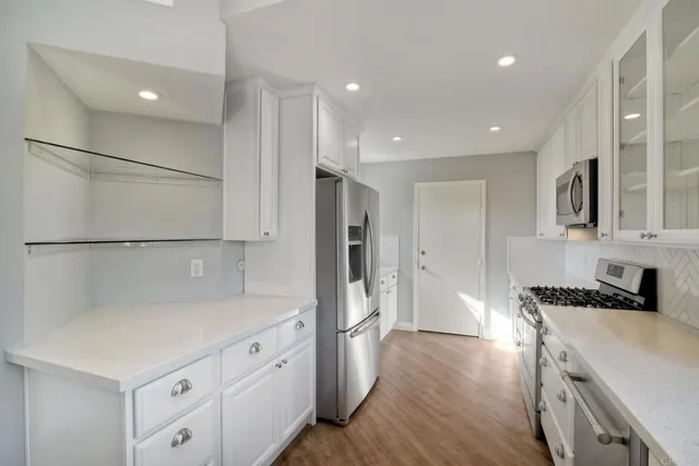 a kitchen with white cabinets and refrigerator