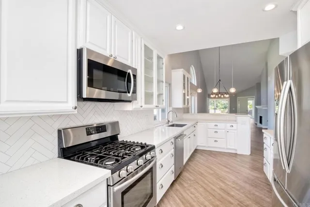 a kitchen with stainless steel appliances a stove a sink and a microwave