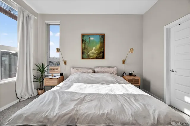 a bed sitting in a bedroom and potted plant with wooden floor