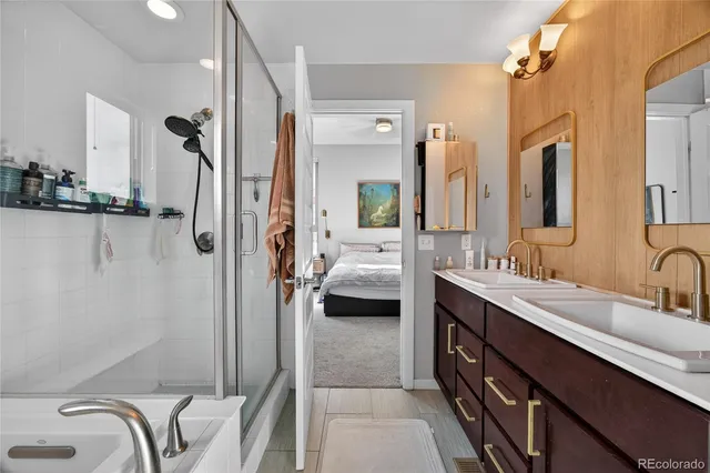 a en suite spacious bathroom with a double vanity sink a mirror and a shower