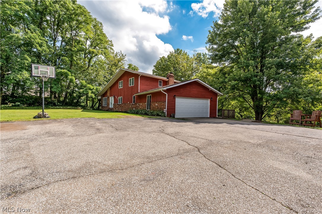 4922 South Ridge Road East Geneva, OH 44041 - Photo 42 of 46 Expansive paved driveway area providing generous parking space, an outdoor basketball hoop, and access to the two-car attached garage.