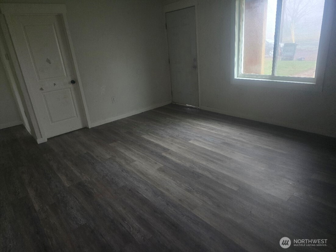 410 East Cherry Avenue Ritzville, WA 99169 - Photo 3 of 22 a view of an empty room with wooden floor and a window