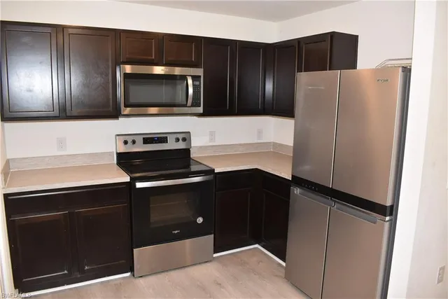 a kitchen with a refrigerator and a stove top oven