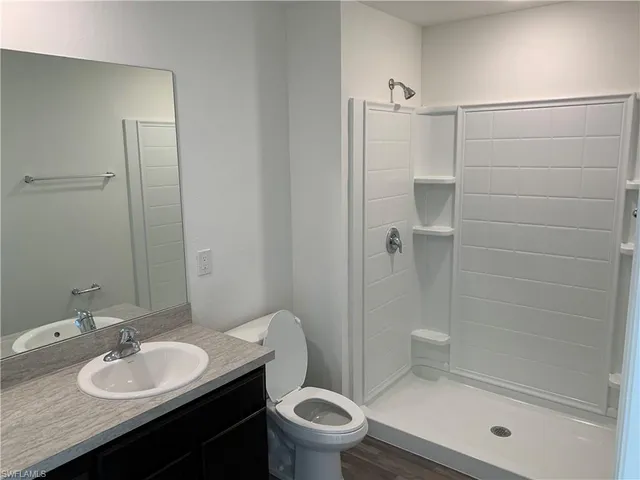 a bathroom with a granite countertop sink toilet and shower