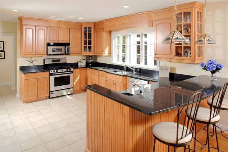 50 Woods Neck Road Orleans, MA 02653 - Photo 3 of 22 a kitchen with stainless steel appliances granite countertop a stove a sink a microwave and dining table