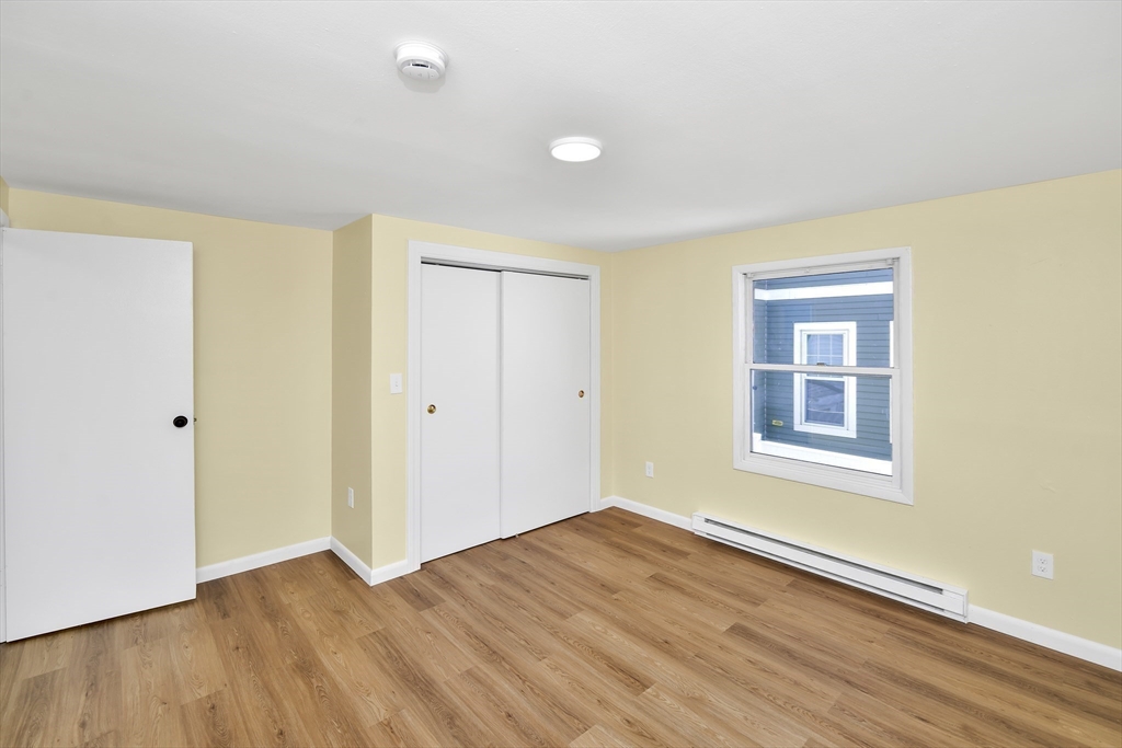 11 Greendale Road, Unit 2 Boston, MA 02126 - Photo 20 of 25 a view of an empty room with wooden floor and a window