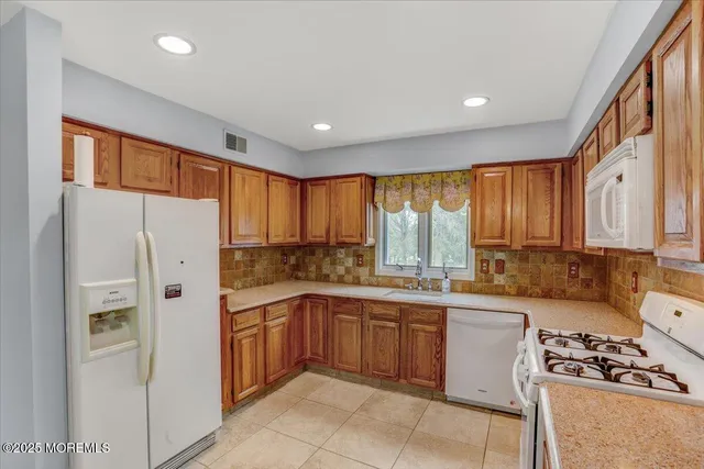 a kitchen with a sink a refrigerator and window