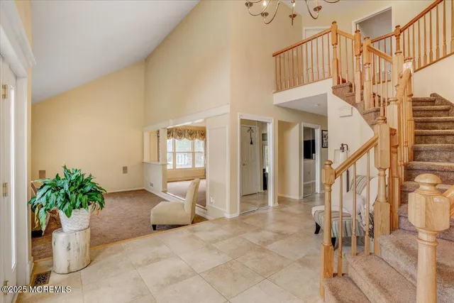 a view of staircase with lots of frames and flower vase