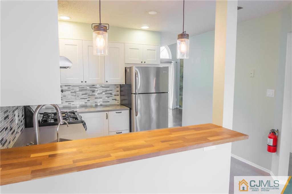 380 Draco Road Piscataway, NJ 08854 - Photo 9 of 35 a kitchen with stainless steel appliances kitchen island granite countertop a refrigerator and a sink