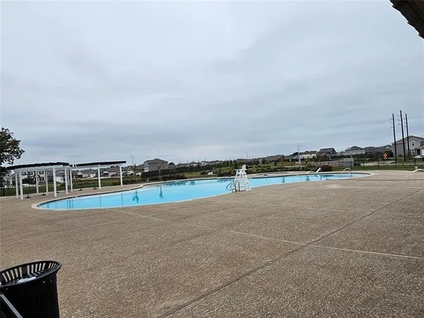 a view of a swimming pool with a bench and some trees